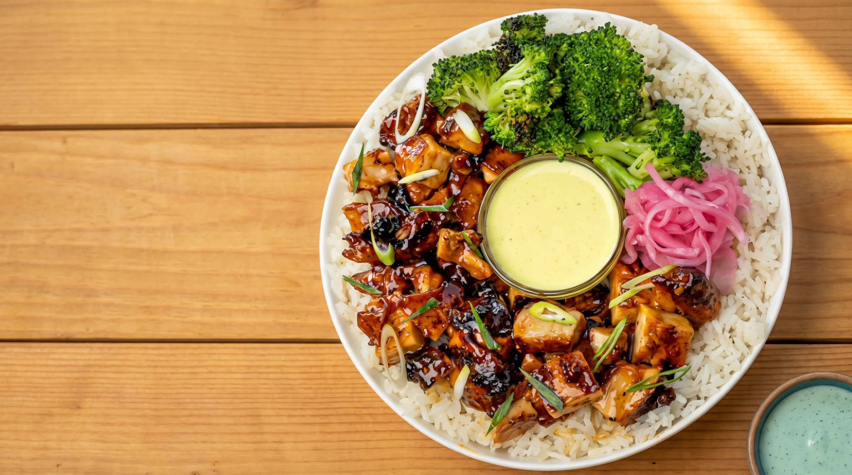 A fresh Bolay bowl of glazed chicken, jasmine rice, charred broccoli, pickled red onions and signature sauce